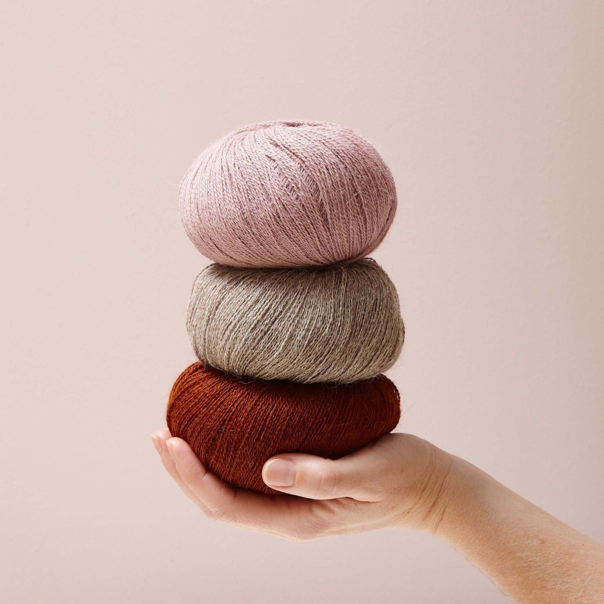 3 Alpaka på hånd med lyserød baggrund